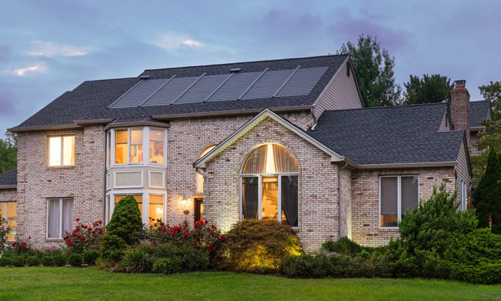 Eco-Friendly House With Solar Roof At Dusk